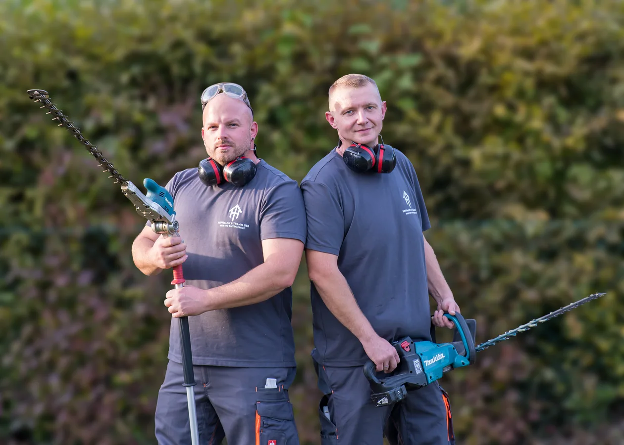 Marcell Hoffmann und Alexander Tramm mit Heckenscheren im Garten